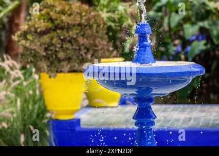 Fontaine avec bassin, peinte en bleu Majorelle, dans le jardin éponyme de Marrakech Banque D'Images