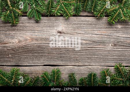 Fond de Noël ou de nouvel an avec une bordure de branches de sapin vert frais sur une table en bois rustique Banque D'Images