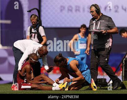 Paris, France. 7 août 2024. Mutaz Essa Barshim (bas l), du Qatar, est assisté par Gianmarco Tamberi, d'Italie, après avoir été blessé lors d'une tentative de saut lors de la qualification masculine en saut en hauteur d'athlétisme aux Jeux Olympiques de Paris 2024 à Paris, France, le 7 août 2024. Crédit : Li Ming/Xinhua/Alamy Live News Banque D'Images