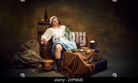 Femme en tenue traditionnelle se détend avec pichet à la main, entourée d'articles rustiques comme des tonneaux, et de la nourriture simple dans une atmosphère tranquille et accueillante. Banque D'Images
