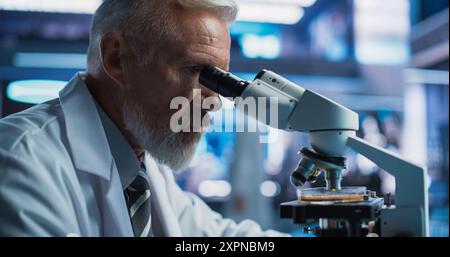 Laboratoire de développement médical : gros plan du scientifique masculin caucasien senior utilisant le microscope, analyse l'échantillon de boîte de Petri. Laboratoire pharmaceutique mener des recherches en biotechnologie, développer de nouveaux médicaments. Banque D'Images