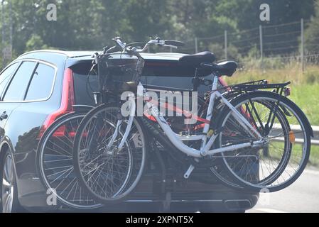 Voiture noire voyageant avec des vélos sur porte-vélos. Banque D'Images