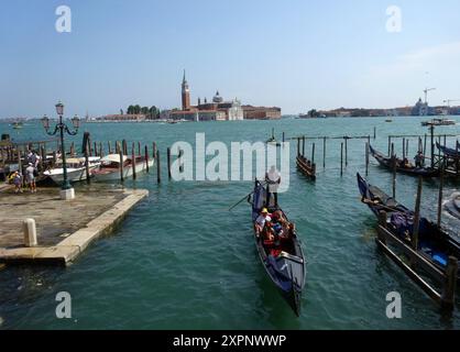 Un gondolier transporte les touristes dans les gondoles sur les canaux de Venise en Italie. Venise est une ville du nord-est de l'Italie et la capitale du Ven Banque D'Images