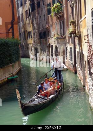 Un gondolier transporte les touristes dans les gondoles sur les canaux de Venise en Italie. Venise est une ville du nord-est de l'Italie et la capitale du Ven Banque D'Images