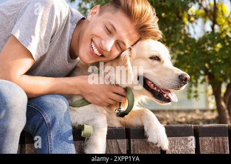 Portrait de propriétaire heureux avec chien mignon Golden Retriever à l'extérieur sur une journée ensoleillée Banque D'Images