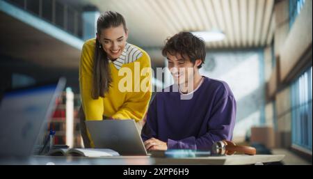 Couple diversifié d'amis et de camarades de classe travaillant sur un projet d'équipe collaborative dans une bibliothèque académique. Jeunes étudiants multiethniques utilisant un ordinateur portable, discutant des sujets de conférence à venir Banque D'Images