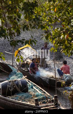 Des personnes réparant des filets de pêche sur un bateau, Pakhiralay, près de Gosaba, South 24 Parganas District, West Bengale, Inde, Asie Banque D'Images