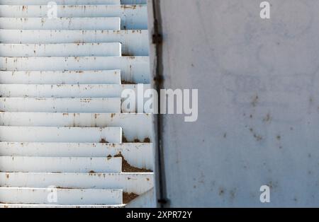 Mur blanc sale autour du coin : perspective d'escalier en béton. Banque D'Images