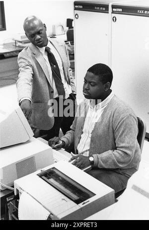 Austin Texas USA, 1990: Les employés entrent des données dans un terminal d'ordinateur tandis que le superviseur observe dans une installation de traitement des données du recensement des États-Unis pendant le compte décennal des personnes vivant dans le pays. ©Bob Daemmrich Banque D'Images