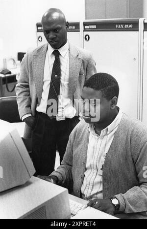 Austin Texas USA, 1990: Les employés entrent des données dans un terminal d'ordinateur tandis que le superviseur observe dans une installation de traitement des données du recensement des États-Unis pendant le compte décennal des personnes vivant dans le pays. ©Bob Daemmrich Banque D'Images