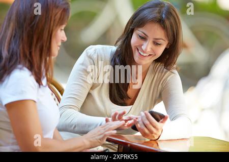 Je cherche un smartphone. Femmes sœurs 35 et 40 ans prenant le café sur une terrasse. Donostia. San Sebastian. Gipuzkoa. Pays Basque- Espagne. Banque D'Images