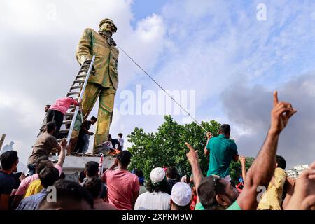 Dhaka, Bangladesh. 5 août 2024. Des gens vandalisent une statue de l'ancien président Sheikh Mujibur Rahman, père du premier ministre Sheikh Hasina, à Dhaka, Bangladesh, le 5 août 2024. Dans un discours à la nation, le chef d'état-major de l'armée, le général Waker-Uz-Zaman, a annoncé que le premier ministre Sheikh Hasina avait démissionné après des semaines de troubles et qu'un gouvernement intérimaire serait formé pour diriger le pays. Banque D'Images