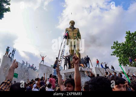 Dhaka, Bangladesh. 5 août 2024. Des gens vandalisent une statue de l'ancien président Sheikh Mujibur Rahman, père du premier ministre Sheikh Hasina, à Dhaka, Bangladesh, le 5 août 2024. Dans un discours à la nation, le chef d'état-major de l'armée, le général Waker-Uz-Zaman, a annoncé que le premier ministre Sheikh Hasina avait démissionné après des semaines de troubles et qu'un gouvernement intérimaire serait formé pour diriger le pays. Banque D'Images