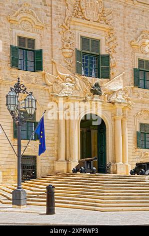 L'Auberge de Castille ; 1740 ; vieux bâtiment en pierre calcaire ; entrée voûtée, volets vert foncé, Baroque, canons, lampadaire, drapeau de l'UE, poste de Premier Banque D'Images