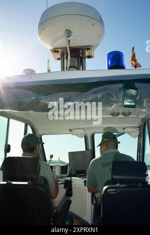 Deux officiers civils de la Guardia surveillent la frontière UE-Afrique depuis un bateau de surveillance dans l'enclave espagnole de Melilla. L'image, prise en juin 2012, illustre un aspect critique des opérations de contrôle aux frontières. Banque D'Images