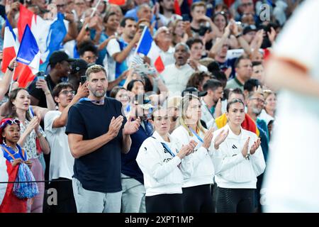 Paris, France. 07 août 2024. Jeux olympiques, Paris 2024, basket-ball, femmes, Allemagne - France, en quarts de finale, l'ancienne superstar de la NBA Dirk Nowitzki (g) et les membres de l'équipe allemande de basket 3x3 (g-d) Svenja Brunckhorst, Sonja Greinacher, Marie Reichert, qui a remporté la médaille d'or olympique, applaudissent l'équipe allemande après la défaite. Crédit : Marcus Brandt/dpa/Alamy Live News Banque D'Images