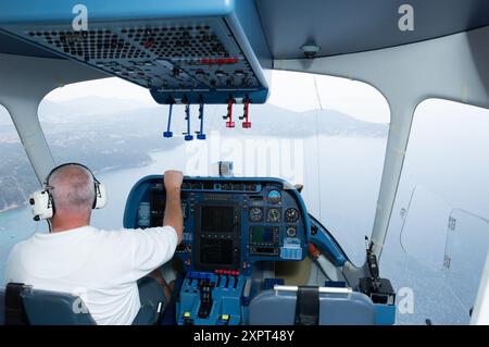 Un pilote navigant dans le cockpit d'un dirigeable Zeppelin NT, profitant d'une vue panoramique sur le paysage français. Le dirigeable est un dirigeable utilitaire rempli d'hélium connu pour ses vols luxueux et calmes. Banque D'Images