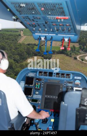 Vue imprenable depuis le cockpit d'un dirigeable Zeppelin NT lors d'un vol au-dessus de la belle campagne française. La photo présente le panneau de commande avancé et le paysage vert ci-dessous. Banque D'Images