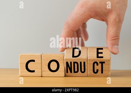 Concept d'entreprise et de code de conduite, symbole du code de conduite. La main de l'homme d'affaires fixe des blocs en bois avec des mots Code de conduite. Copier l'espace. Banque D'Images