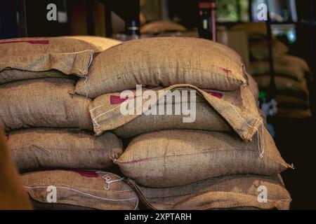 Sacs empilés de grains de café en toile de jute dans un entrepôt Banque D'Images