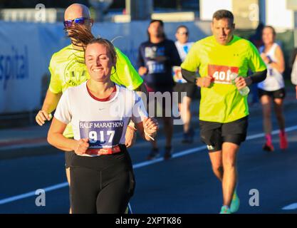 West Islip, New York, États-Unis - 22 octobre 2023 : coureurs courant un semi-marathon avec le soleil qui brille sur eux sur long Island. Banque D'Images