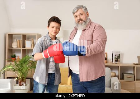 Heureux grand-père et son petit-fils mignon pendant la formation de boxe à la maison Banque D'Images