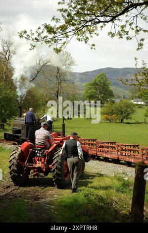 « Winifred » avec un train de chariots en ardoise passant devant un tracteur d'époque et des ré-acteurs entre Ysgubor FIAS et Pentrpiod halt. Banque D'Images