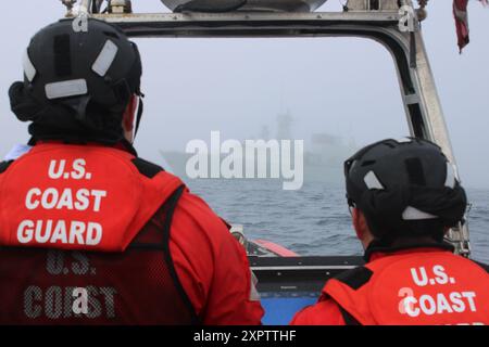 Les membres de l’équipage de la Garde côtière américaine Cutter Kimball (WMSL 756) à bord d’un navire de coupe IV de 26 pieds survolant l’horizon observent le Kimball lors d’un exercice de dépassement avec le navire de la Marine royale canadienne NCSM Regina pendant que Kimball patrouille dans la mer de Béring, le 18 juillet 2024. Au cours de la patrouille de 122 jours de Kimball, l’équipage a interagi avec des partenaires stratégiques à Victoria, au Canada, renforçant les relations en se concentrant sur les intérêts communs dans la mer de Béring et la région arctique en expansion. Photo de la Garde côtière américaine par l'enseigne James Bongard. Banque D'Images