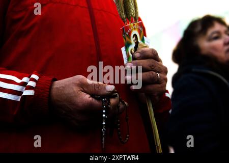 Buenos Aires, Argentine. 07 août 2024. Fidèle tient un crucifix en attendant la messe dans la paroisse de San Cayetano. Comme chaque 7 août, la Saint Cayetano Day est célébrée. Sous la devise « Saint Cayetano ami du peuple, donnez-nous un cœur de solidarité », le sanctuaire situé dans le quartier de Buenos Aires à Liniers, se prépare à recevoir des milliers de fidèles, qui viennent le remercier et lui demander du pain, de la paix et du travail. Crédit : SOPA images Limited/Alamy Live News Banque D'Images