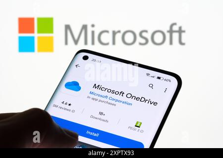 Installation de l'application Microsoft OneDrive sur smartphone avec logo Microsoft en arrière-plan, Stafford, Royaume-Uni, 7 août 2024 Banque D'Images