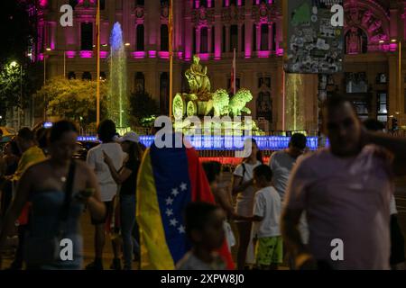 Madrid, Espagne. 07 août 2024. Les résidents vénézuéliens de Madrid prennent des photos de la fontaine de Cibeles illuminée aux couleurs du drapeau vénézuélien. Ce soir, le conseil municipal de Madrid a illuminé la fontaine de la Plaza de Cibeles et la façade du palais de Cibeles en hommage au peuple vénézuélien. Crédit : SOPA images Limited/Alamy Live News Banque D'Images