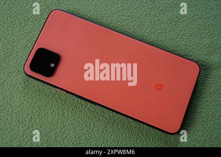 Terengganu, Malaisie - 23 août 2024 : gros plan du smartphone google pixel 4 orange sur fond vert Banque D'Images