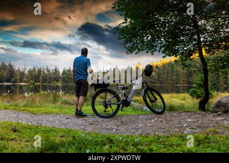 Un cycliste profite de l'atmosphère du soir à Feldsee dans la Forêt Noire Banque D'Images