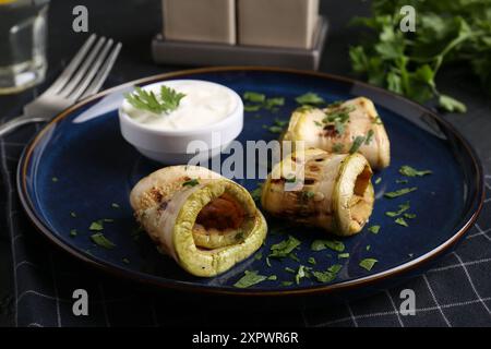 Savoureuses tranches de courgettes grillées servies sur une table grise Banque D'Images