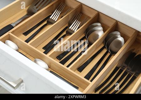 Boîte avec couverts dans le tiroir, gros plan. Rangement des ustensiles de cuisine Banque D'Images