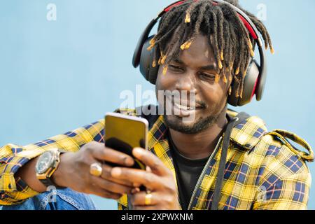 homme noir avec un casque écrivant sur son téléphone Banque D'Images