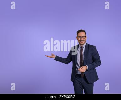 Portrait de beau gestionnaire de marketing souriant montrant l'espace de copie pour la publicité d'affaires. Heureux entrepreneur masculin présentant et recommandant de nouveaux Banque D'Images