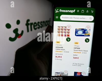 Personne tenant le smartphone avec la page Web de la société allemande de vente au détail Fressnapf Holding se devant le logo. Concentrez-vous sur le centre de l'écran du téléphone. Banque D'Images