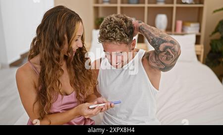 Un couple heureux célèbre un résultat positif de test de grossesse ensemble dans leur chambre, symbolisant l'amour et la croissance de la famille. Banque D'Images