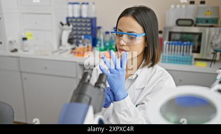 Jeune scientifique spécialisée analysant des échantillons dans un laboratoire urbain Banque D'Images