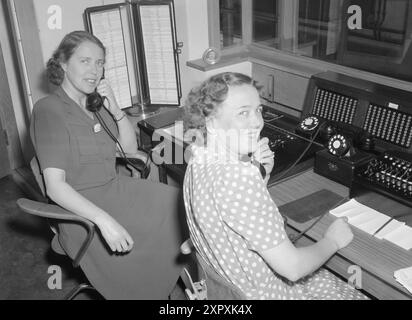 Current 1948 : femmes qui dirigent des doubles livesfemmes qui travaillent à double emploi. Elles participent à la vie professionnelle et sont aussi des ménagères. MRS Elsa Fagerhaug (à droite) est une dame de standard dans une grande entreprise de neuf heures et demie à quatre heures et demie. Le petit fils de neuf ans est doué pour s'occuper de lui-même, mais avant de commencer l'école, il a dû être à la garderie. Mme Fagerhaug a une chambre et une cuisine, de sorte que le fils aîné, âgé de 16 ans, vit avec son père Nordland, où il va à l'école. Elle s'épanouit à la fois comme femme au foyer et avec son autre travail, même si elle n'a pas beaucoup de temps à perdre pour wha Banque D'Images