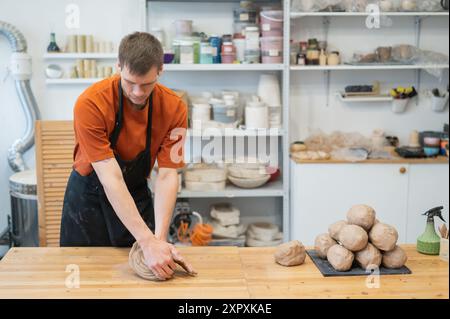 Potter pétrit l'argile avant de l'utiliser dans l'atelier. Banque D'Images