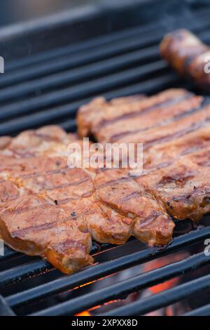 Les steaks et les saucisses sont sur le gril et ont atteint le point de cuisson souhaité Banque D'Images