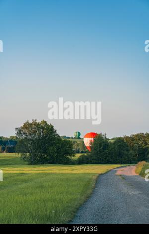 Une montgolfière atterrit dans un champ vert Banque D'Images