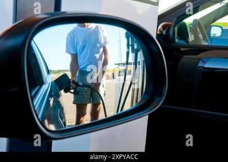 Homme tenant un pistolet à gaz, ravitaillement dans une station-service. Banque D'Images