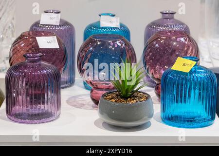 Des vases en verre coloré sont vendus en magasin. Pots pour bouquets de fleurs. Banque D'Images