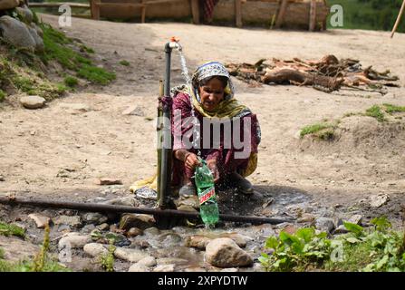 Srinagar, Inde. 07 août 2024. Srinagar, Cachemire, Inde, le 07 août 2024 : les femmes nomades recueillent de l'eau d'un robinet près de la célèbre destination touristique Yousmarg, située à 48 kilomètres de Srinagar au Cachemire. Cette région isolée manque de services essentiels tels que les distributeurs automatiques de billets, la couverture du réseau mobile et les dispensaires médicaux. Photo danoise Showkat/Sipa USA. Crédit : Sipa USA/Alamy Live News Banque D'Images