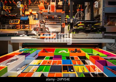 Tiroir avec compartiments colorés pour les pièces. Atelier à domicile. Mur avec outils. imprimantes 3d. Banque D'Images