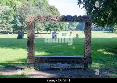 Les pierres Gorsedd et les poubelles photographiées à travers le cadre photo géant en bois à Bute Park, Cardiff, Royaume-Uni. Banque D'Images