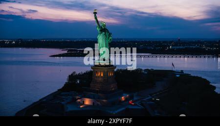 Image aérienne de la Statue de la liberté. Photo en hélicoptère du monument patriotique dans un magnifique coucher de soleil, debout sur une Liberty Island dans le port de New York Banque D'Images